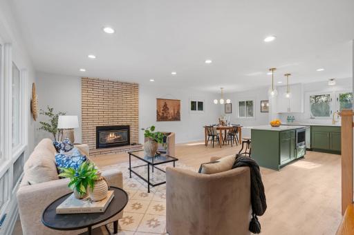 The spacious open-concept main level features a cozy brick fireplace and a beautifully updated kitchen, creating an inviting space for relaxing and entertaining.