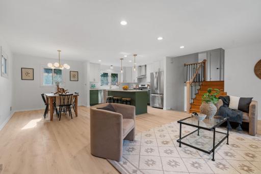 This bright, modern living space flows effortlessly into the dining area and kitchen, highlighted by stylish lighting, updated finishes, and a generous center island.