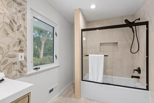 This fresh, modern bathroom combines neutral tile, updated finishes, and natural light to create a bright and calming space.