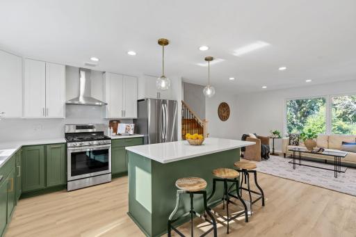 A generous center island with seating anchors the kitchen and opens directly to the sun-filled living room, making entertaining effortless