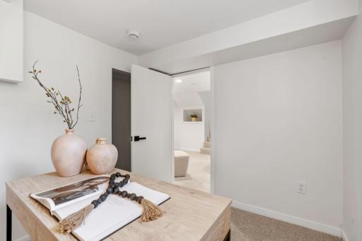 A second view highlights the room’s flexible layout, neutral finishes, and convenient connection to the lower-level living area