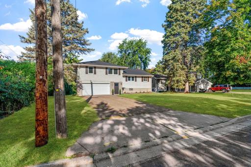 Set on a spacious, tree-lined lot, this inviting home offers an attached garage, mature landscaping, and a generous driveway