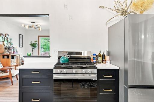 The stainless steel five-burner gas range is a standout feature. A thoughtfully designed prep area with ample drawers provides easy-access storage and an efficient workspace for meal preparation.