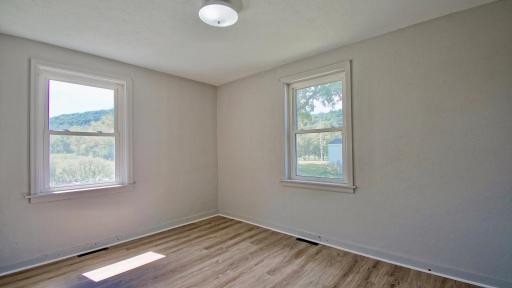 Tucked into the front left corner, this charming bedroom offers a front-row seat to nature with sweeping, peaceful views from every window.