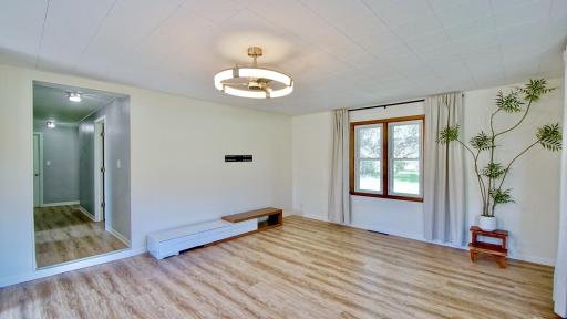 View from living room into the main level hallway leading to the kitchen, three bedrooms, and full bath of home.