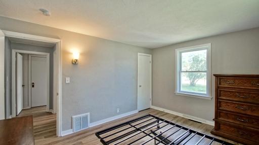 Interior view of primary bedroom. Third bedroom is through the doorway straight ahead. Full bath is through the doorway to the right.