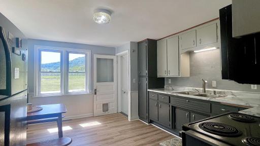 Enjoy every meal surrounded by scenic scenery in this bright, expansive eat-in kitchen. Stairs to lower level are through the door on the right.