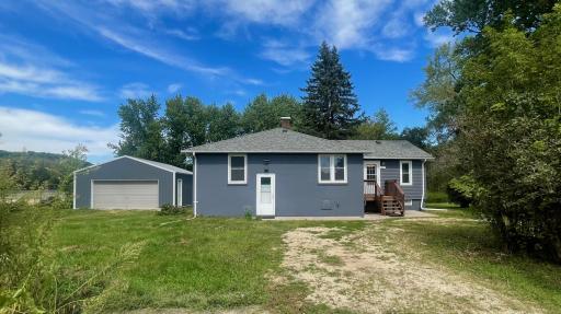 A charming front deck highlights the main entrance, complemented by a spacious, oversized two-car detached garage for maximum convenience and storage.
