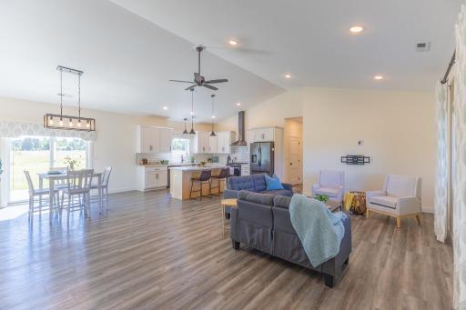 Bright, open-concept living area with vaulted ceilings and easy flow into the kitchen and dining area.
