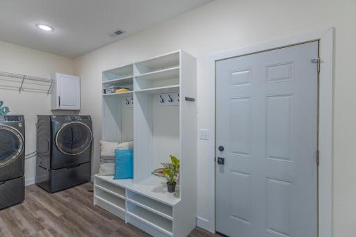 Main-floor laundry and mudroom with built-in storage and direct garage access.