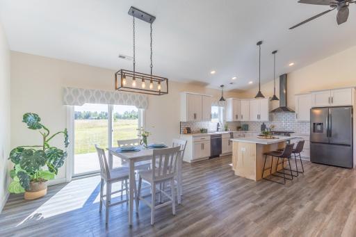Dining area with patio access and an open view into the kitchen.