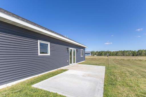 Concrete rear patio provides convenient outdoor space directly off the home.