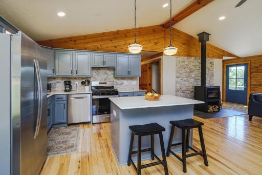 The kitchen opens to the vaulted family room with a new woodstove and hickory hardwoods that run throughout.