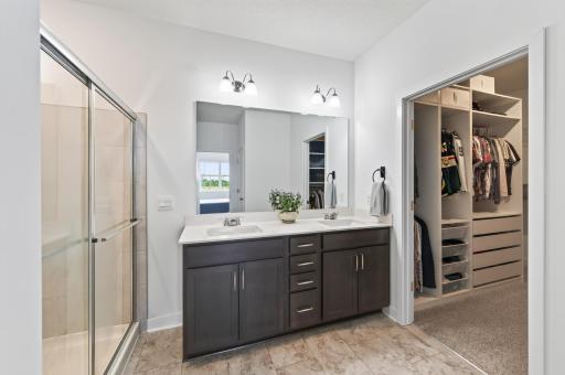 Raised height dual sink vanity, walk in shower and walk-in closet with custom closet system