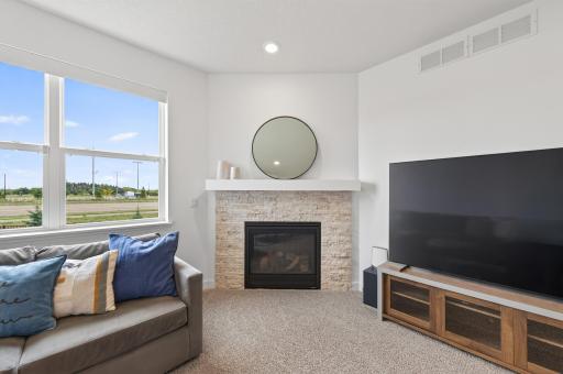 Gas fireplace with stacked stone surround and wood mantel