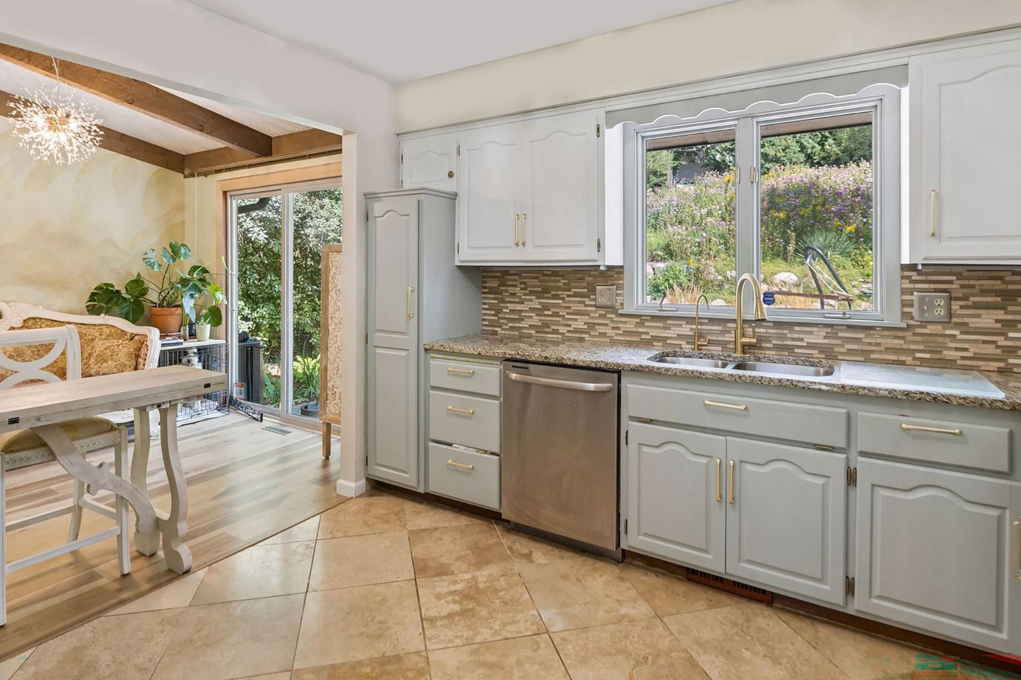 13. Kitchen window overlooking a picturesque backyard hillside filled with native flowers.jpg