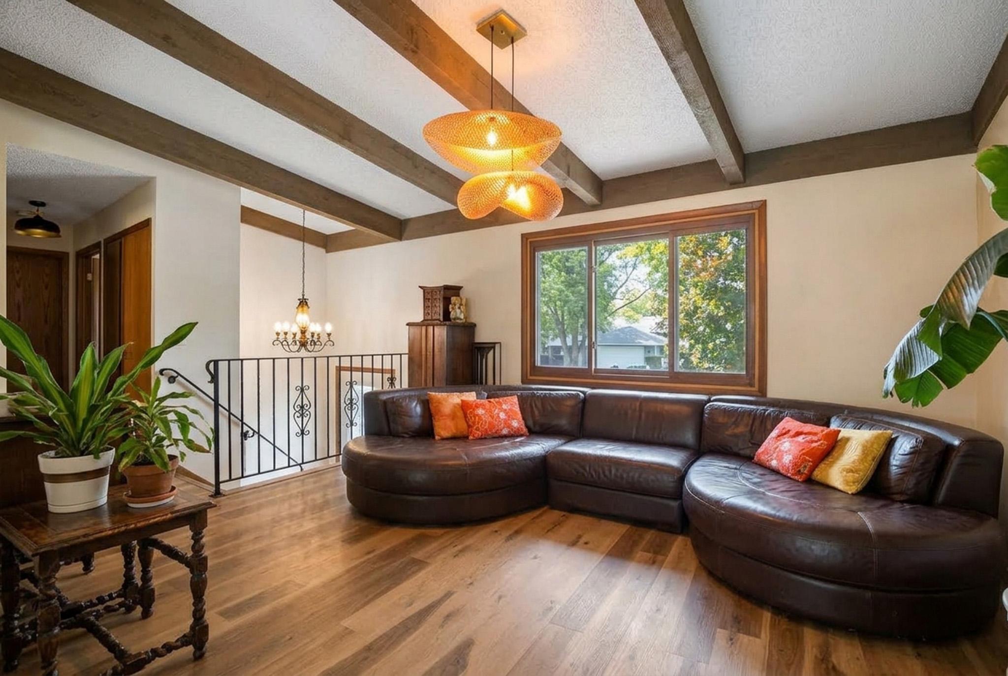 2. Vaulted living space framed by exposed beams and dramatic modern rattan pendants, complete with polished floors and ample room for large-scale furnis.jpg