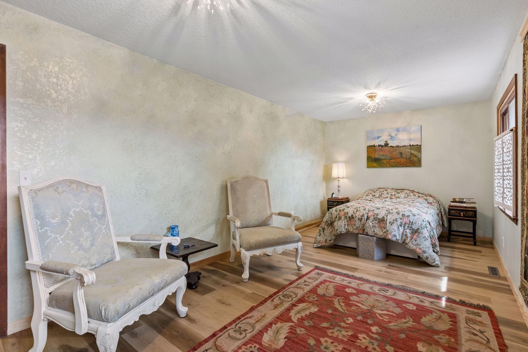 19. Very generous secondary bedroom with decorative textured wall accent and crystal chandeliers.jpg