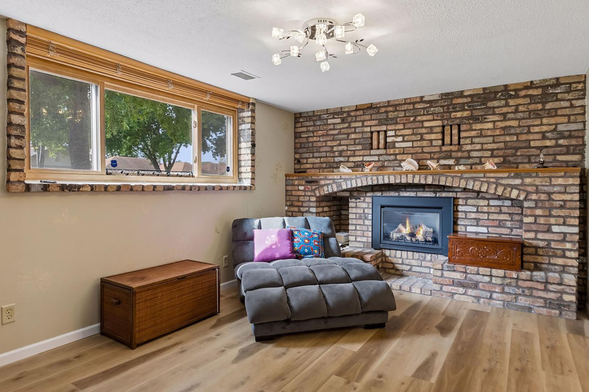 24. Sunlit family room featuring custom 3-function lighting, window views of the front yard flowers and a gas fireplace for cosy evenings.jpg