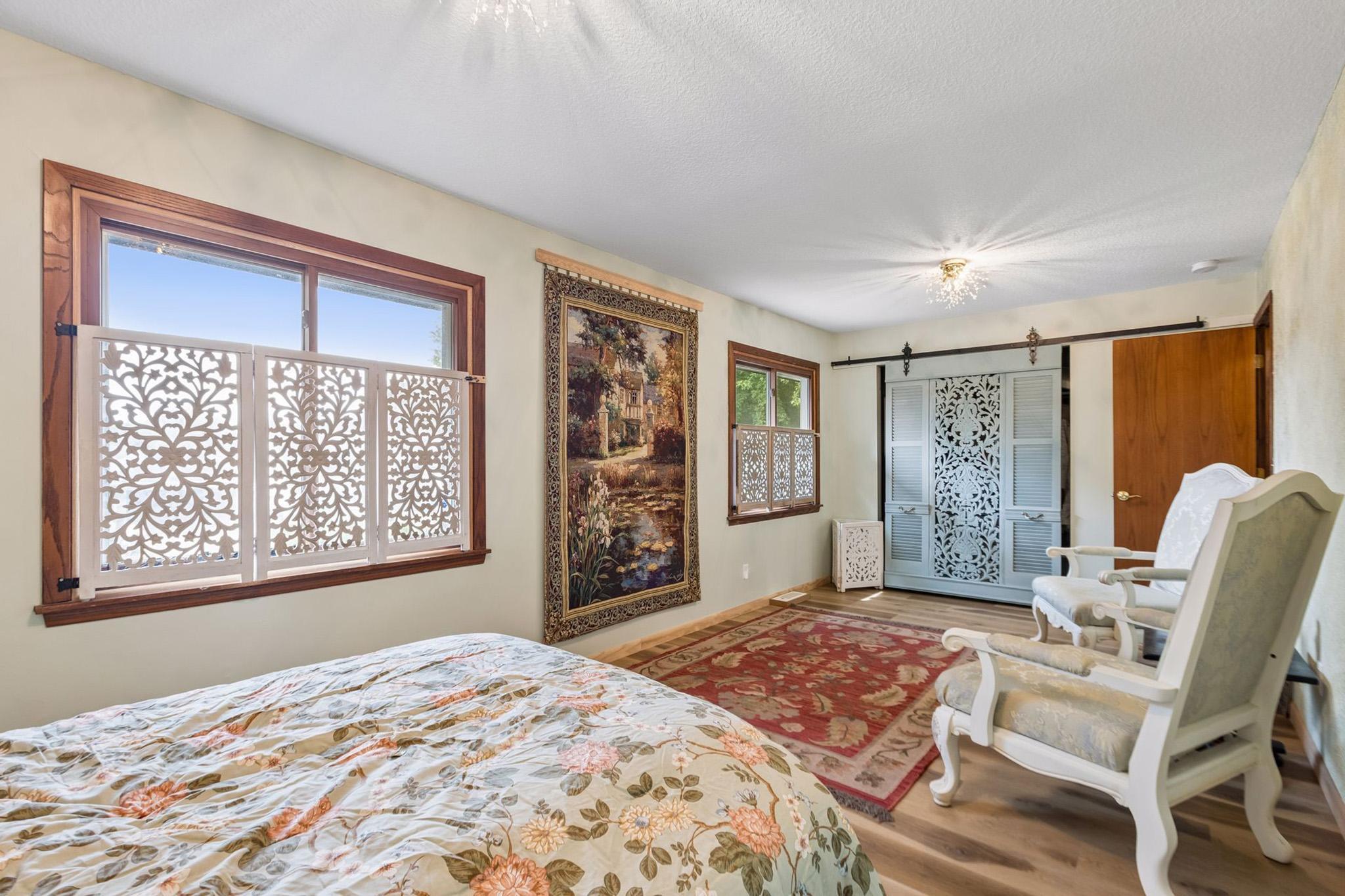 20. Secondary bedroom filled with natural light from two expansive windows, highlighted by unique architectural and design touches.jpg