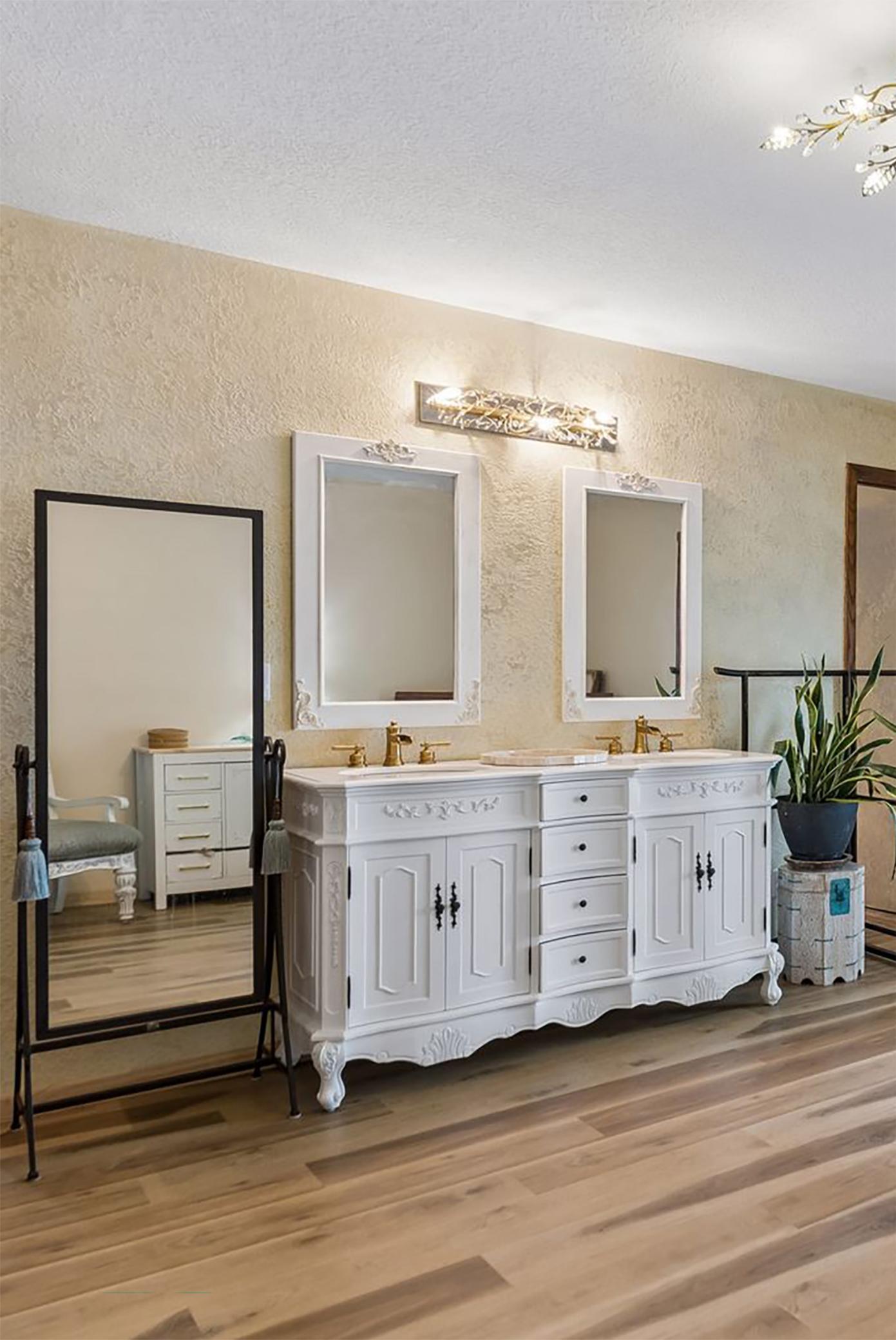 16. Exquisite ornate vanity topped with durable quartz, set against a decorative textured backdrop and accented by sparkling crystal light fixture.jpg