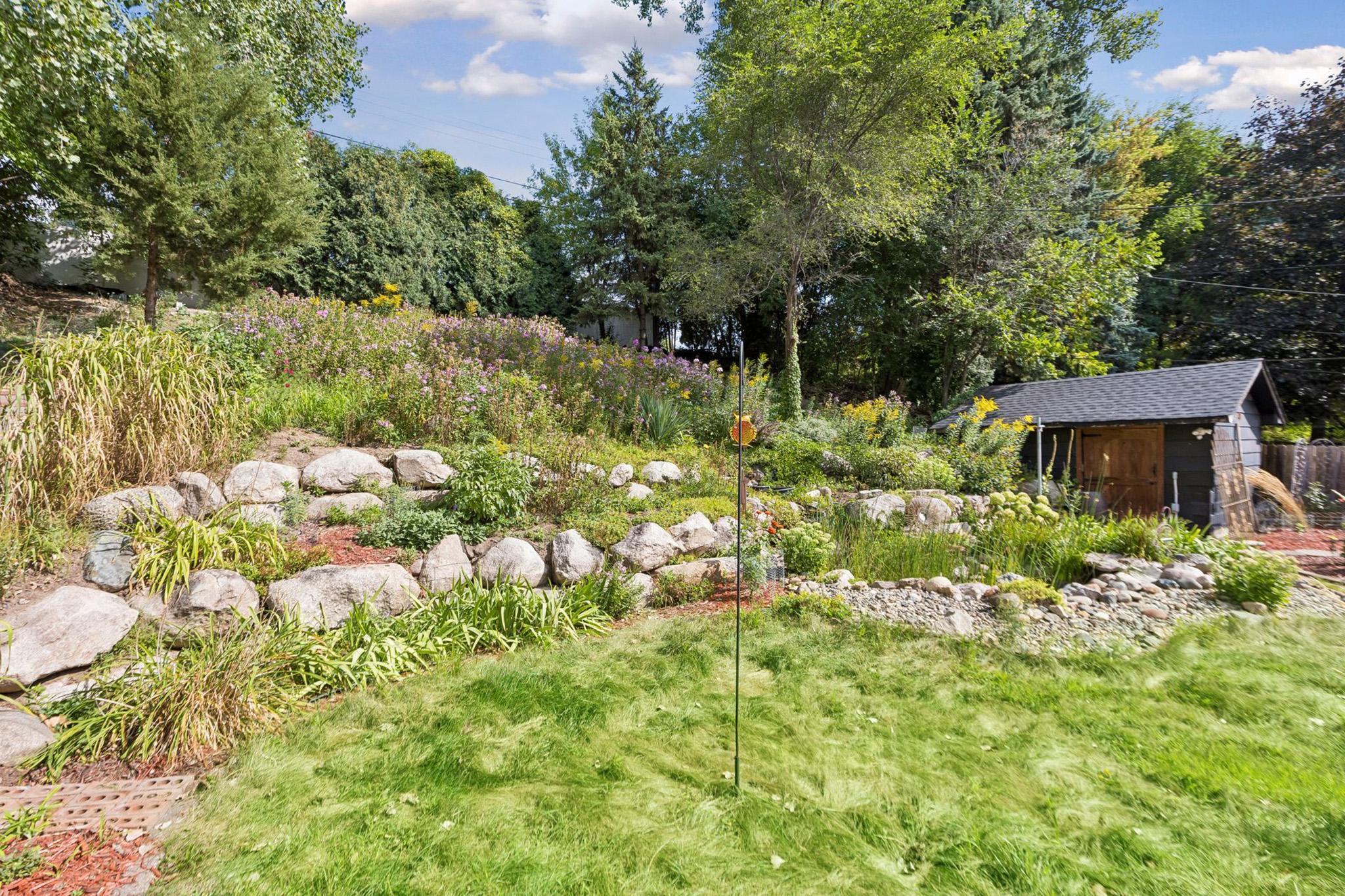 32. Gently sloping rear garden filled with a continuous display of colorful summer flowers.jpg