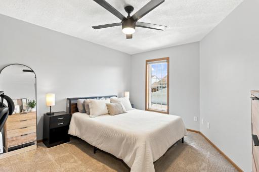 Secondary bedroom on the upper level with its own walk-in closet and a new ceiling fan.