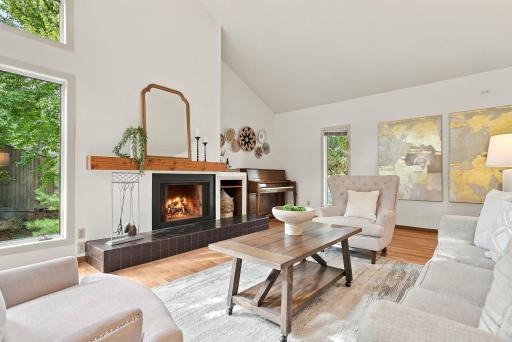 The fireplace anchors the living room while walls of windows bring the outdoors in.