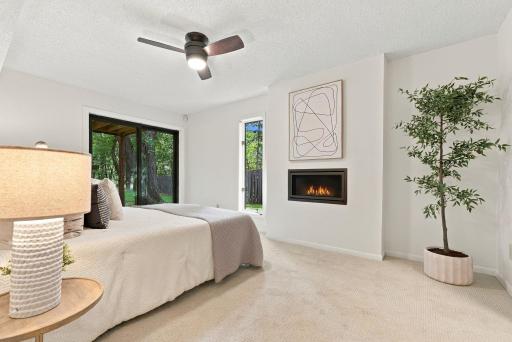 A spacious bedroom features direct outdoor access and a fireplace.