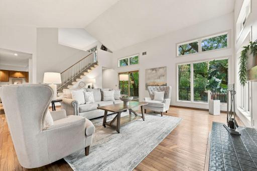 Large windows and doors connect the interior with the wooded backyard setting.