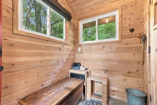 Windows bring natural light and views of the wooded setting into the sauna.