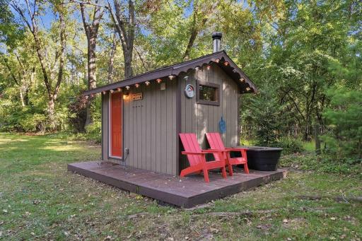 A charming detached sauna adds something truly special to the outdoor setting.