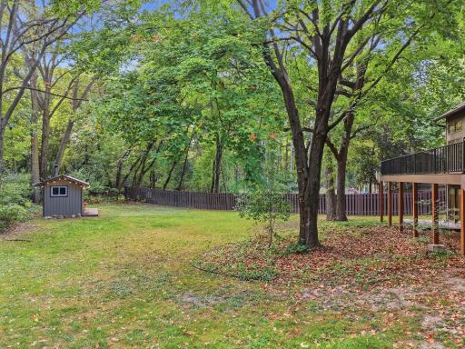The backyard provides open lawn, mature trees, and room for outdoor activities.