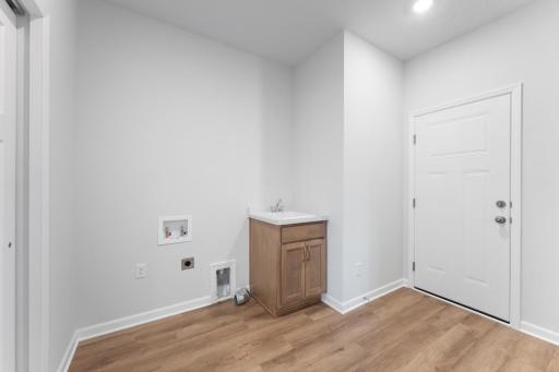 The laundry area features a sink and cabinet to stay organized on laundry day.