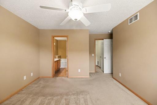 Primary bedroom with a full bath and walk in closet
