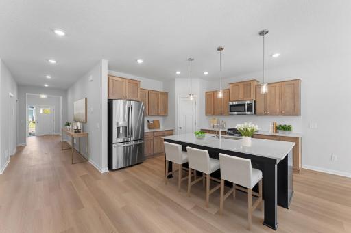 The inviting kitchen comes nicely appointed with stainless appliances, walk-in pantry, quartz countertops with subway tile backsplash, and large island providing additional seating, storage and prep space. Virtually staged.