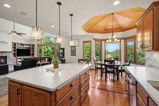 Open kitchen with center island, hard-surface countertops, stainless appliances, and sightlines to the great room and dining area.