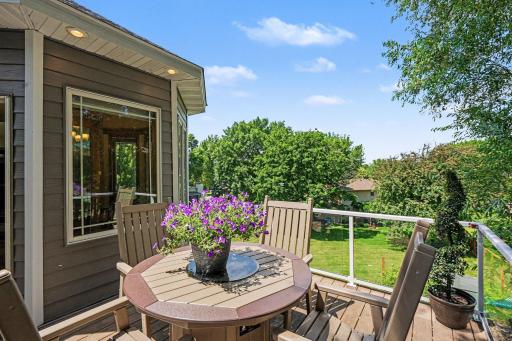 Maintenance-free deck with aluminum rail and glass panels off the dining area, overlooking the landscaped backyard.