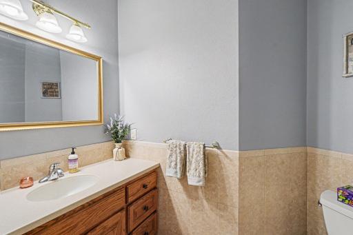Main level half bath with tile floor, conveniently located off the entryway.