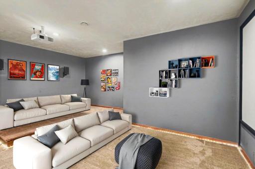 Lower level theater room with tiered seating, a projection screen, and supplemental heat.
