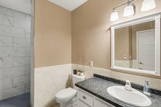 Three-quarter bath with custom shower on the lower level serving both lower level bedrooms. Updated in 2023