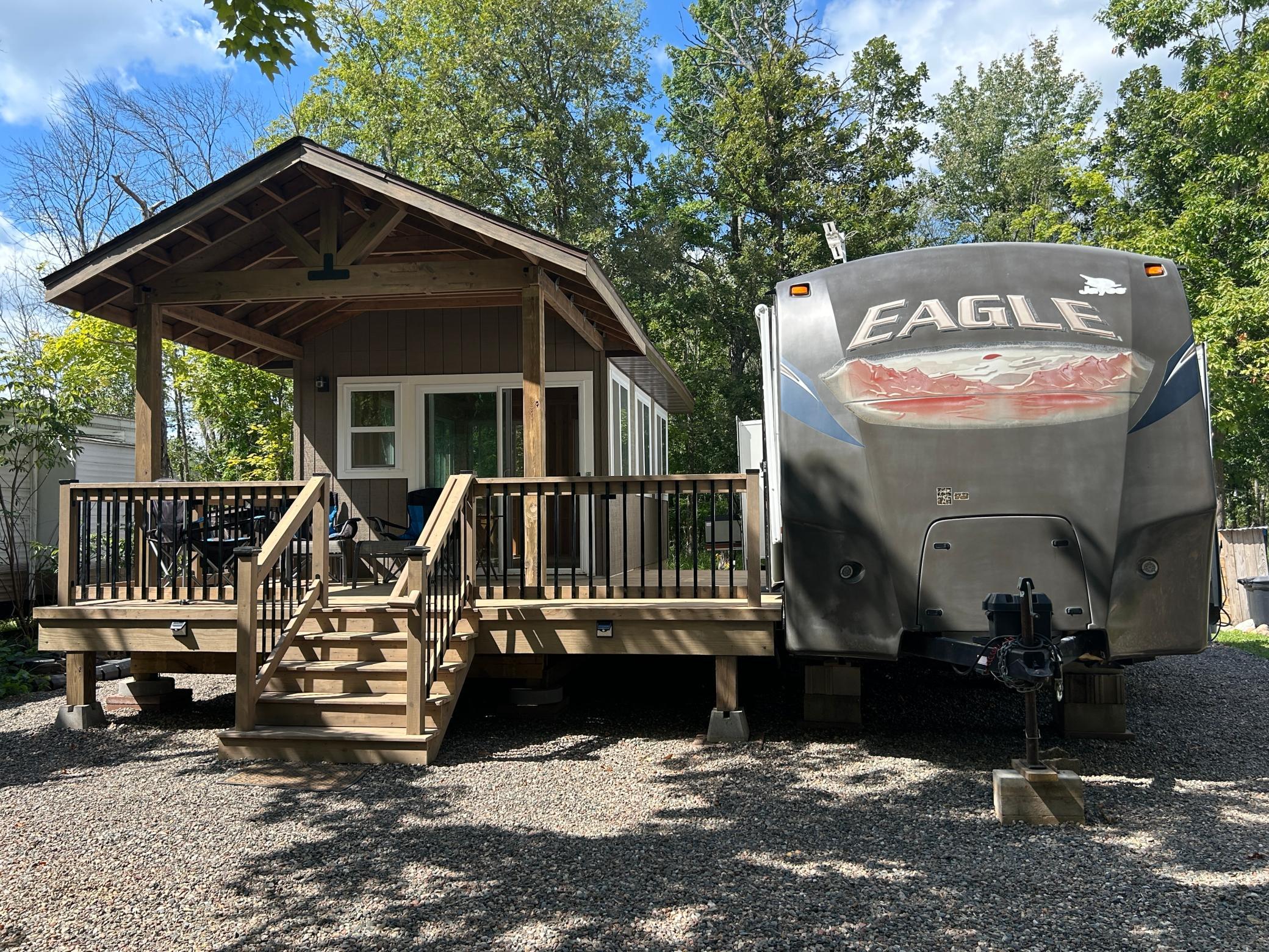Closer view of the lot, fully rocked for easy maintenance, the fabulous "Minnesota Room" and 2013 Jayco Eagle travel trailer, like new!
