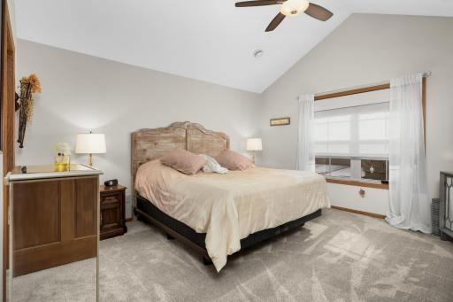 Primary bedroom with vaulted ceiling with fan has brand new carpet