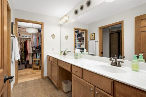 Primary bathroom has generous counter space with double sinks and a fantastic walk-in closet with custom organizer!
