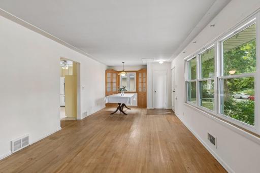 Through the doorway on the left, the kitchen is close at hand. Love how the blonde wood of the oak floors is repeated on the wall by the two china cabinets.