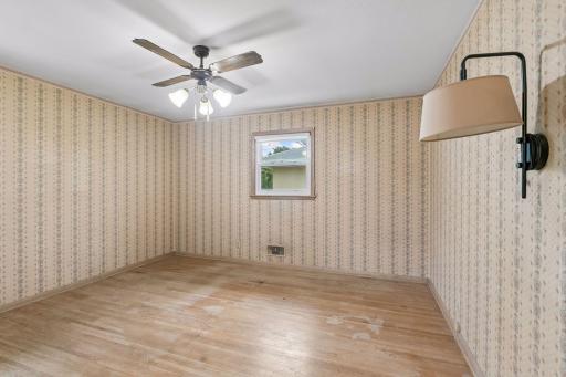 The largest of the three main floor bedrooms. Once again imagine the floors refinished and the wallpaper replaced with a fresh coat of paint.