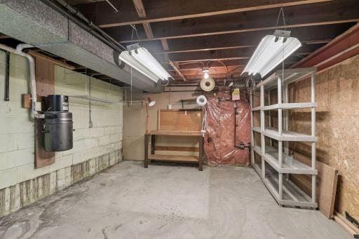 That cylinder hanging on the wall is a central vacuum. The attachments are in the main hall closet. Left behind are some nice shelving units and a work bench for the buyer.
