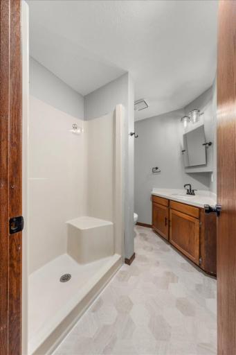 Additional view of 3/4 Bath with new flooring, toilet, hardware, facucet, lighting, mirror, and bathroom accessories!