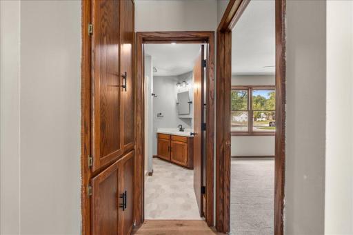 Small hallway leading to main floor bedroom, three-quarter bath and view of linen closet to the left.
