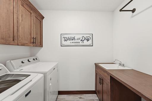 A must!! Upper level laundry room complete with storage and sink.